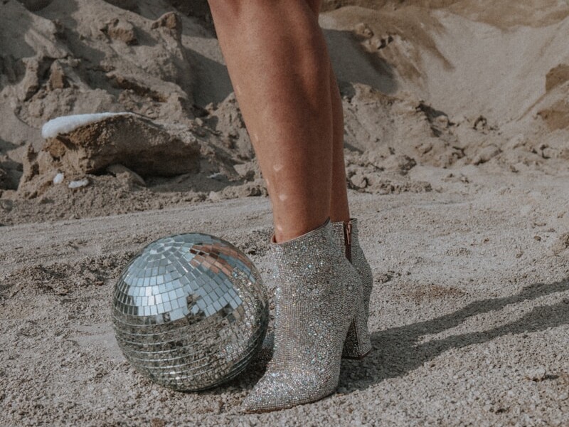 a woman's legs in high heels and a disco ball